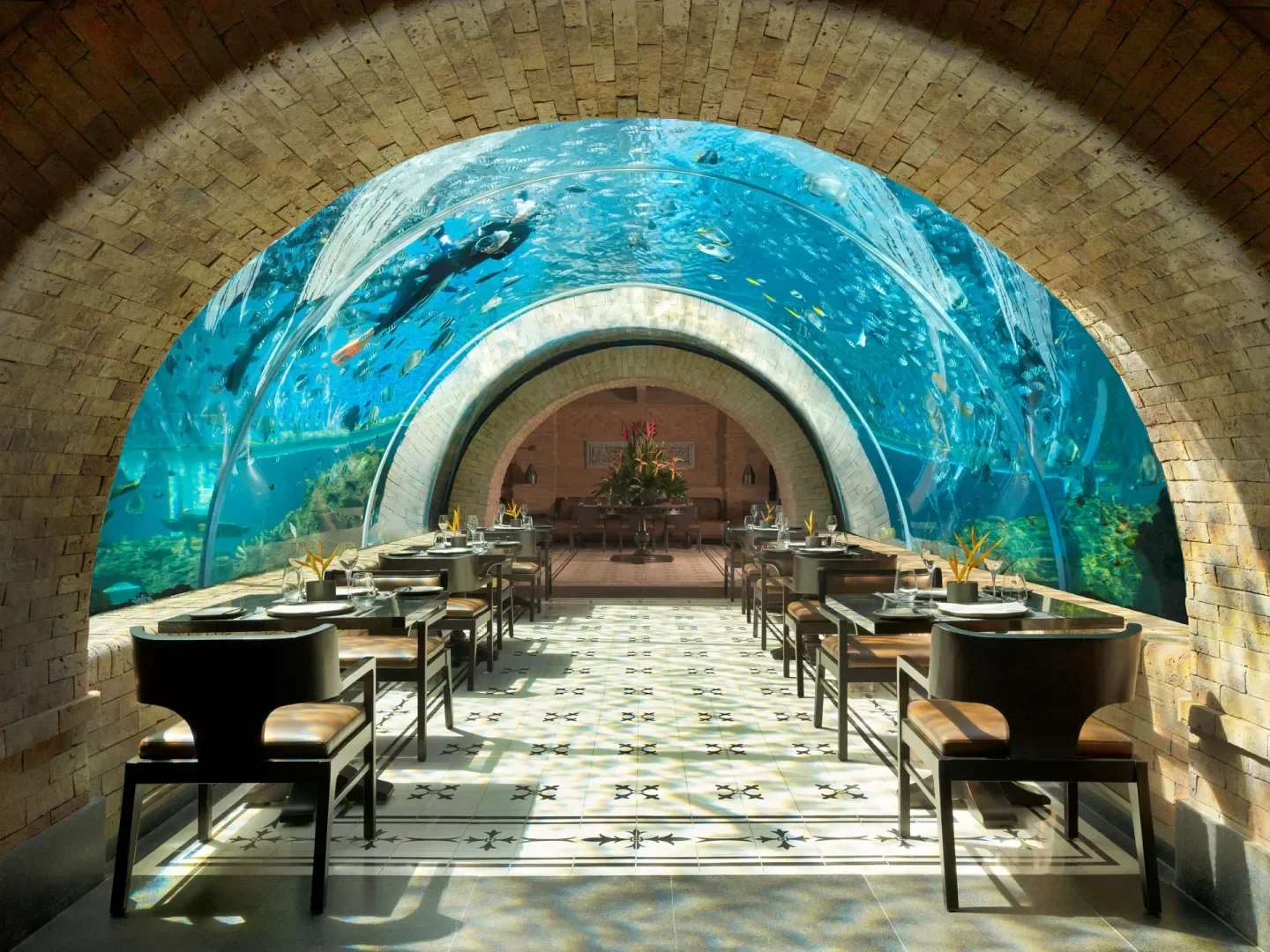 Dining at Koral Restaurant in Bali with underwater aquarium views and elegant setting