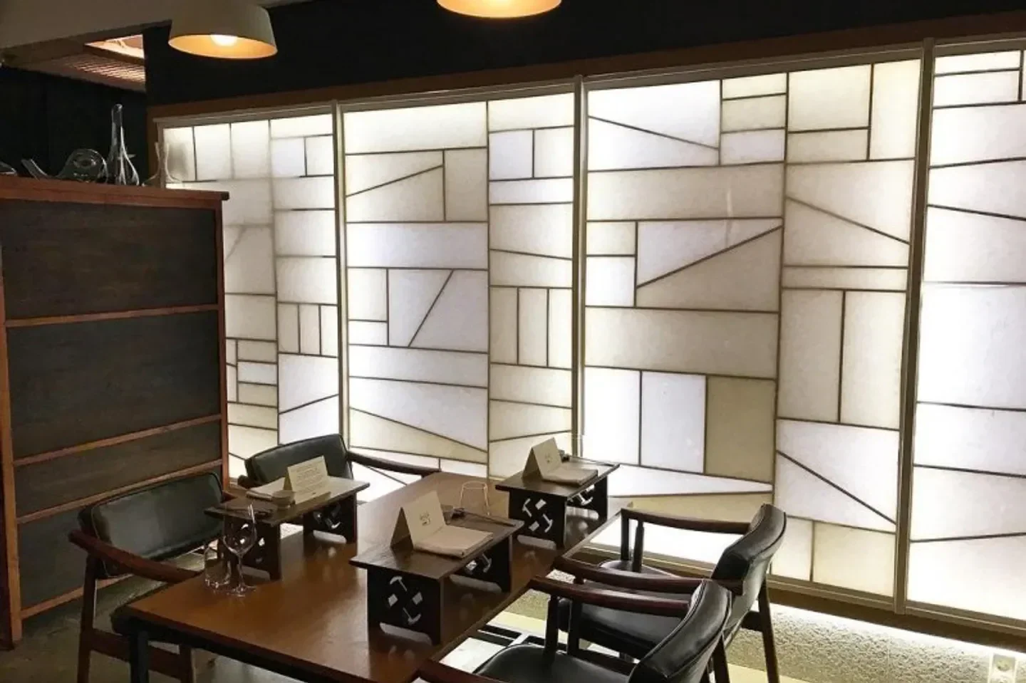 Interior of Kwonsooksoo in Seoul, featuring geometric walls and intimate dining tables.