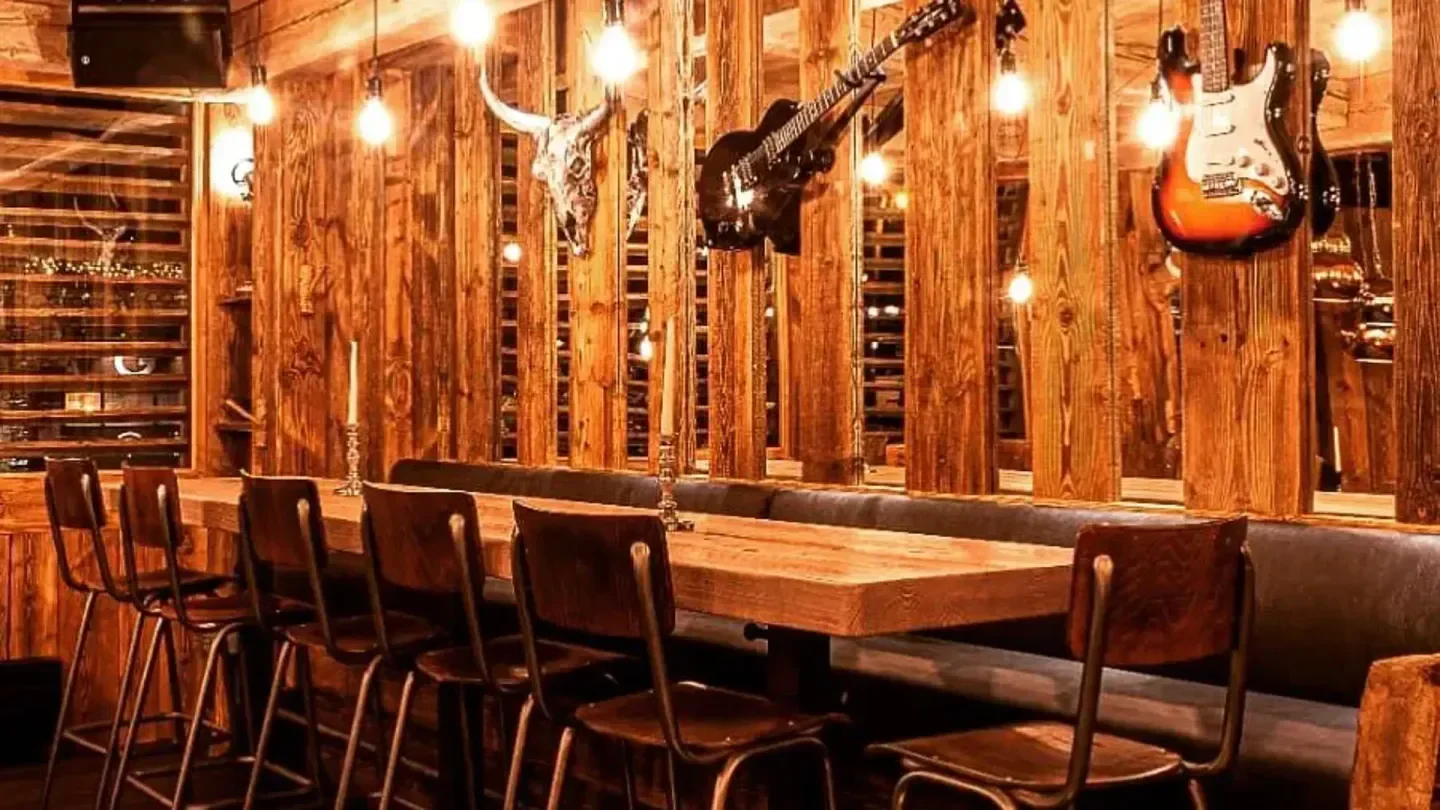 Interior of La Baraque restaurant in Val-d'Isère with guitars and wooden accents.
