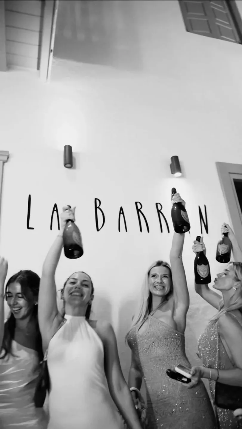 Friends celebrating with champagne bottles at La Barran nightclub in Mykonos