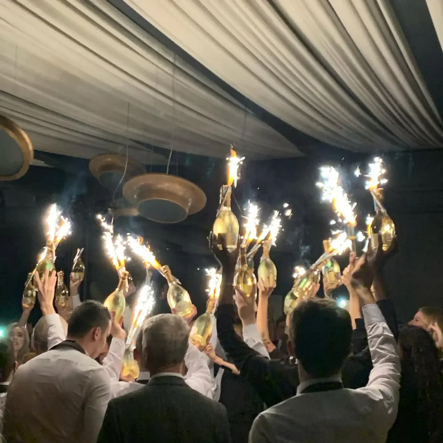 Celebration at La Bullona nightclub in Milan with champagne bottles and sparklers.