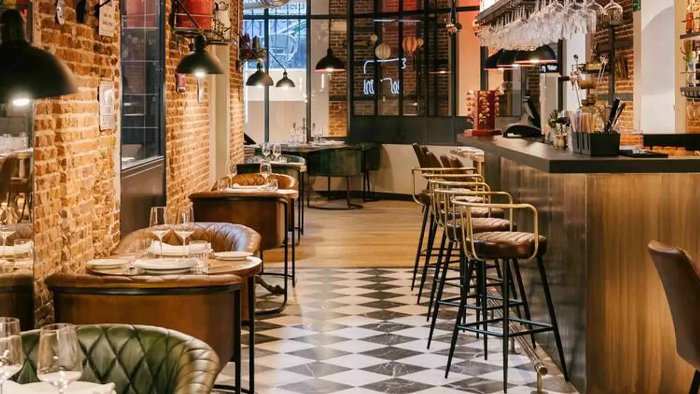 Interior of La Cabrera restaurant in Madrid featuring brick walls and elegant seating.
