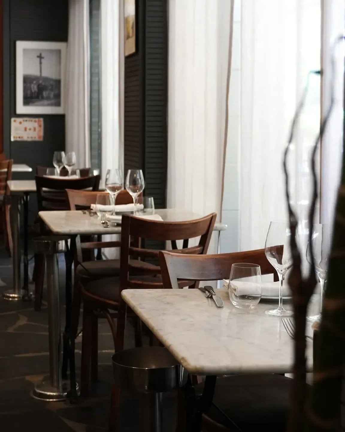 Interior dining at La Cagouille restaurant in Paris, featuring marble tables and elegant decor.