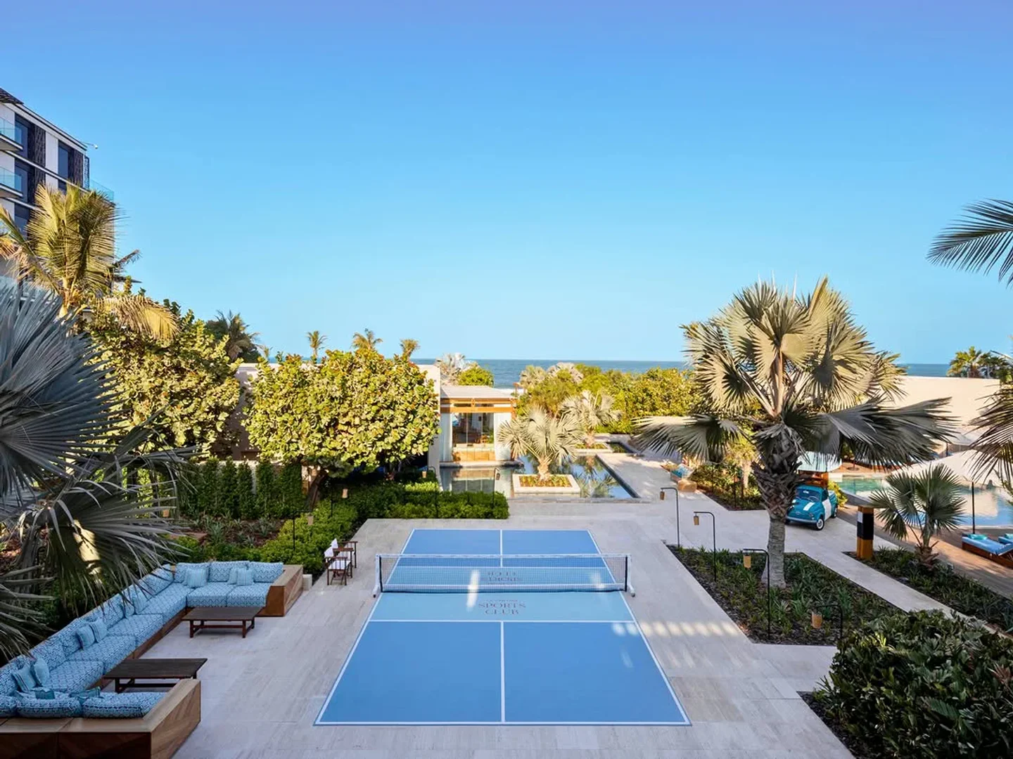 La Cantine Beach club in the city featuring a pickleball court and lounge seating with ocean view