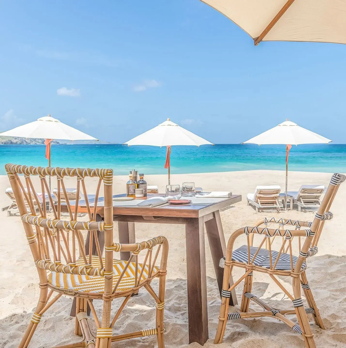 Beachfront dining at La Case beach club in St. Barts, with ocean view and umbrellas.