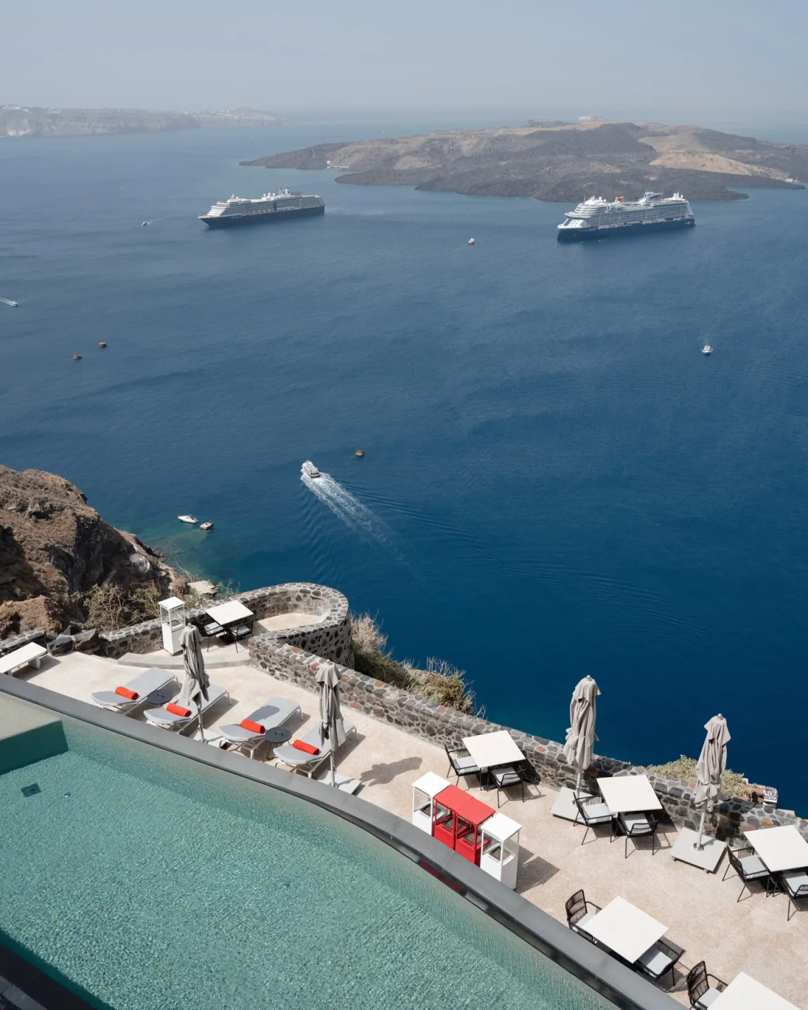 View from La Colline restaurant overlooking the Aegean Sea with cruise ships and Santorini caldera