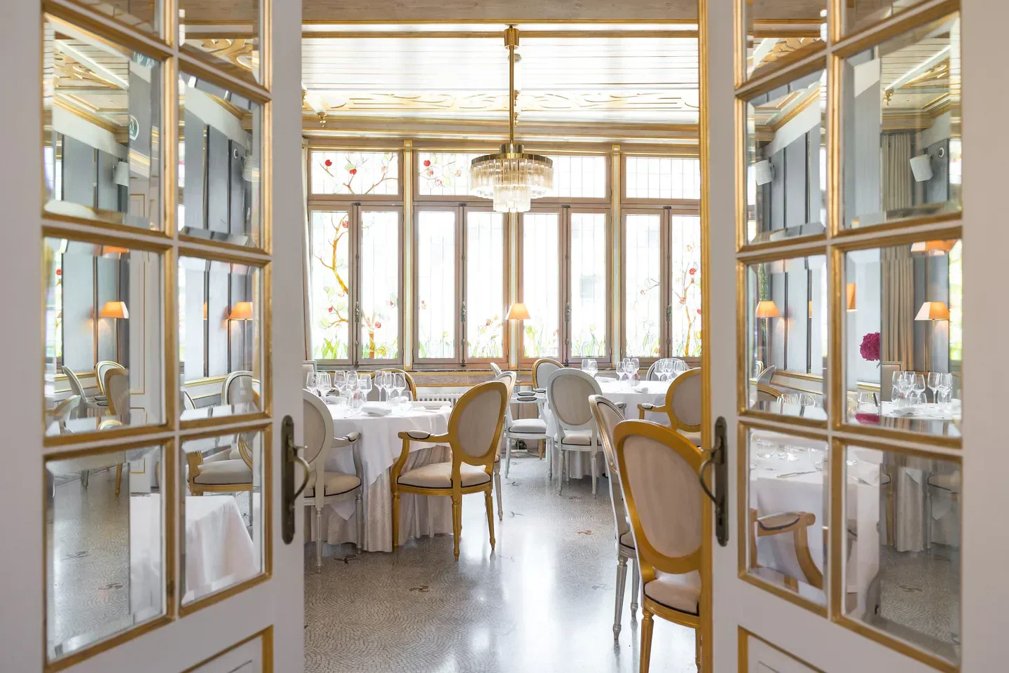 Elegant dining room at La Cristallerie restaurant in Luxembourg, seen through doorway