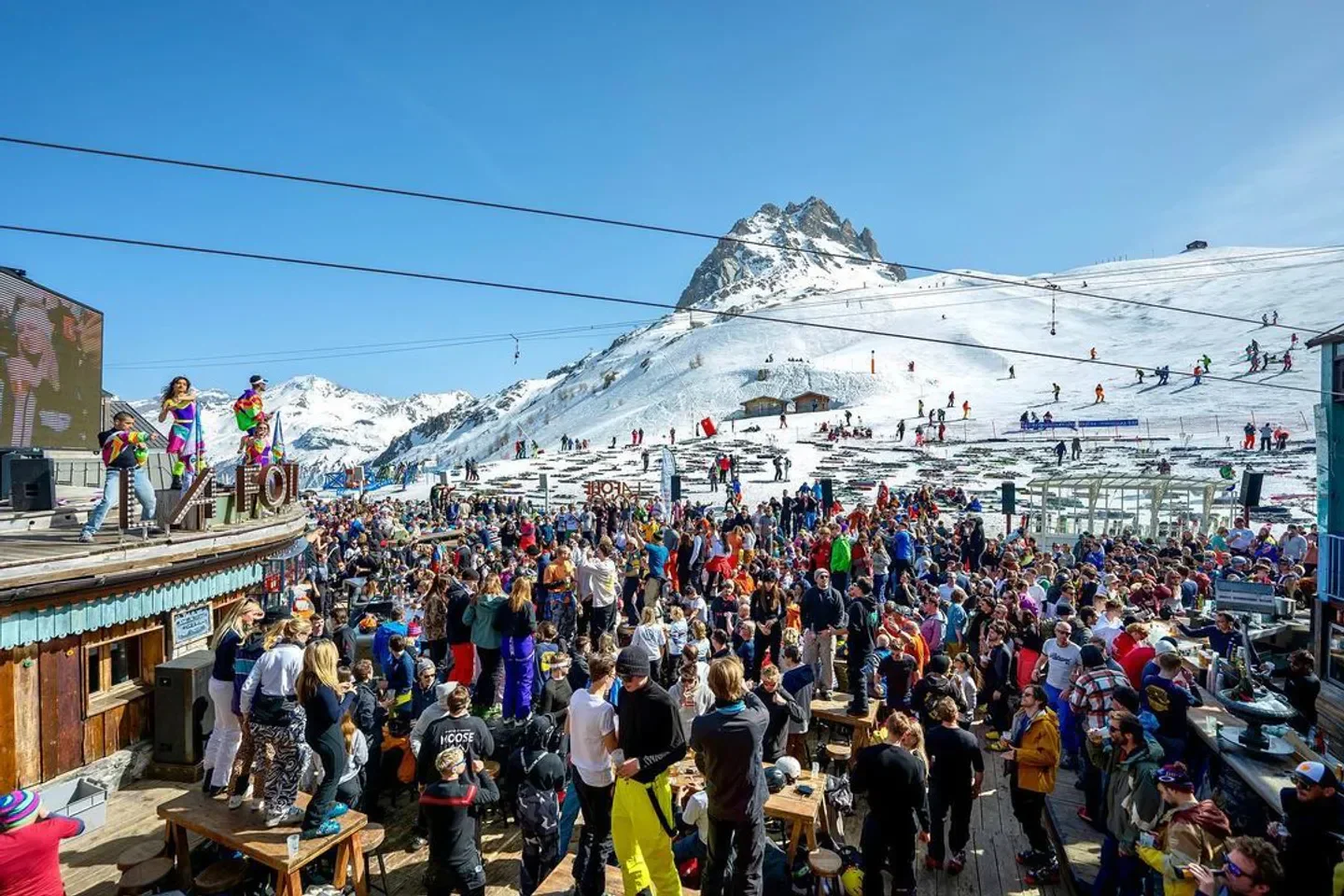 Energetic crowd at La Folie Douce nightclub in Val-d'Isère with mountain backdrop.