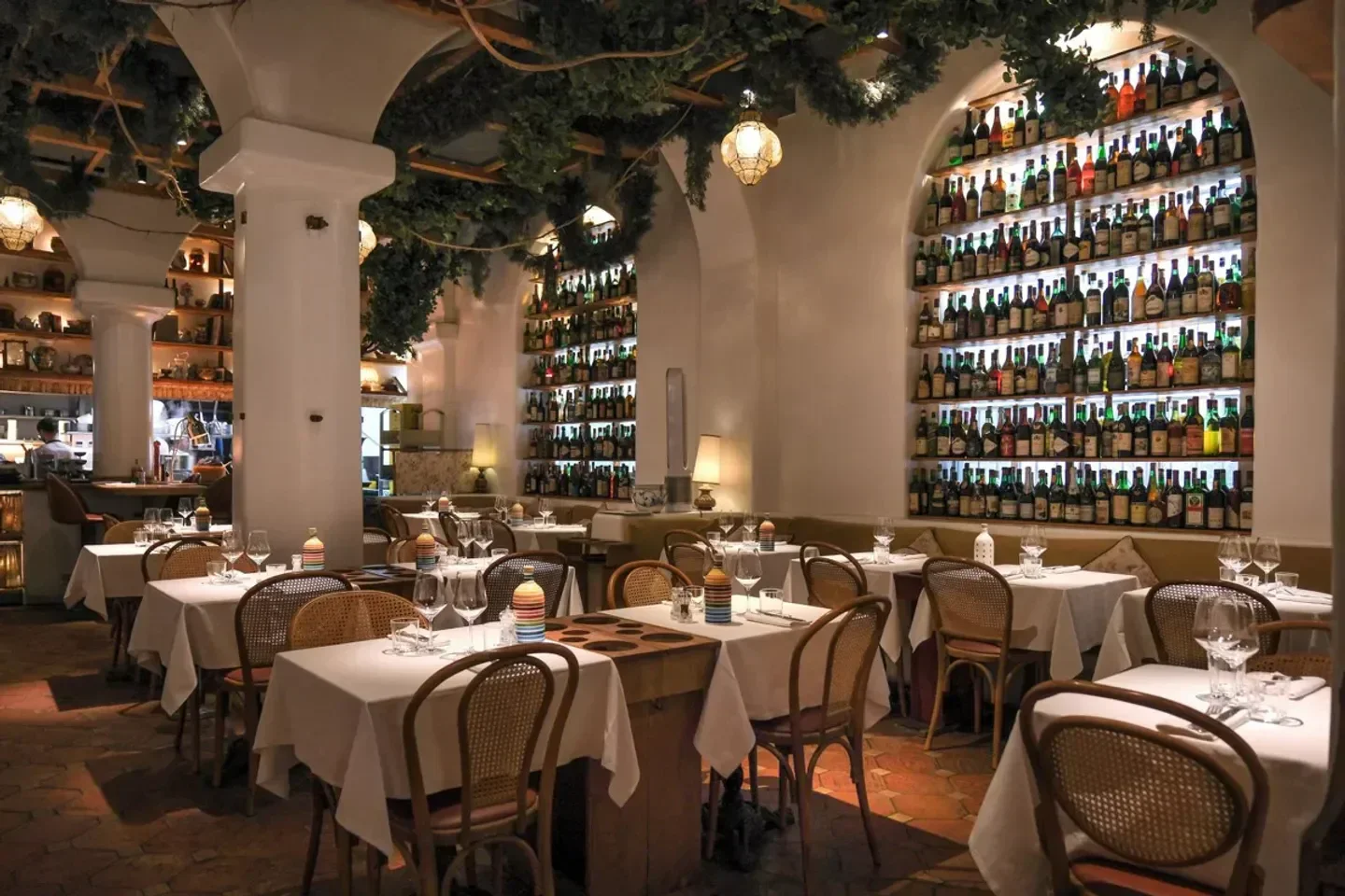 Cozy dining room at La Gioia restaurant in Milan, with wine bottle displays and ambiance.