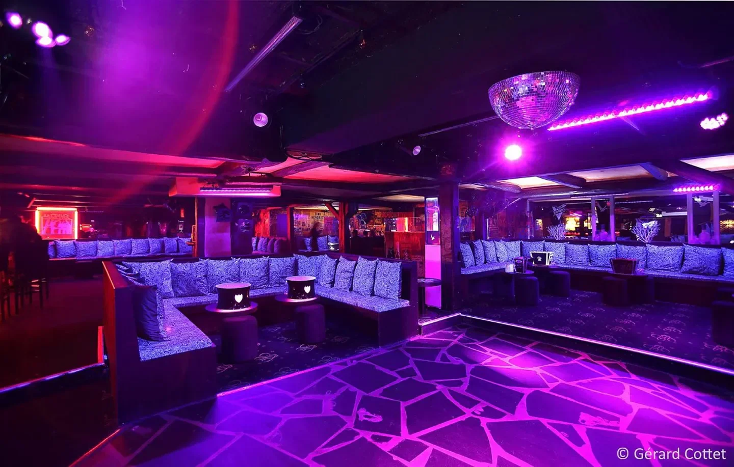 Interior of La Grange nightclub in Courchevel with disco ball and purple lighting.