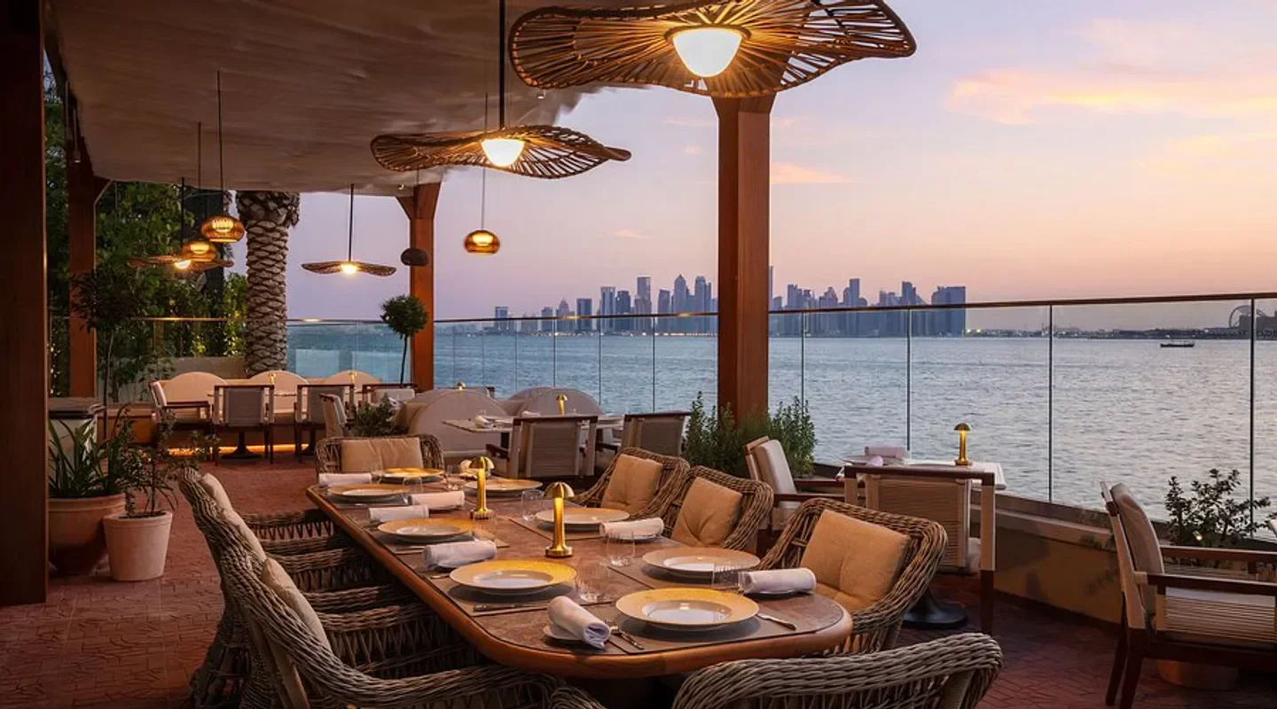 Outdoor dining at La Méditerranée Robuchon in Doha, overlooking the city skyline.