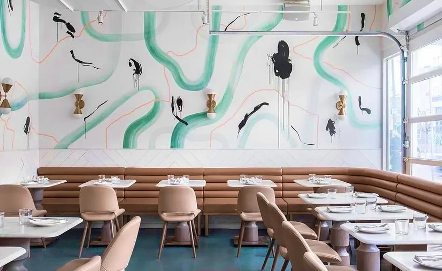Interior of La Palma restaurant in Toronto, with stylish design and artistic mural on wall.
