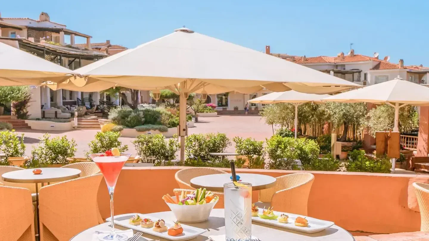 Outdoor dining at La Pergola in Giardino restaurant in Porto Cervo with cocktails and appetizers