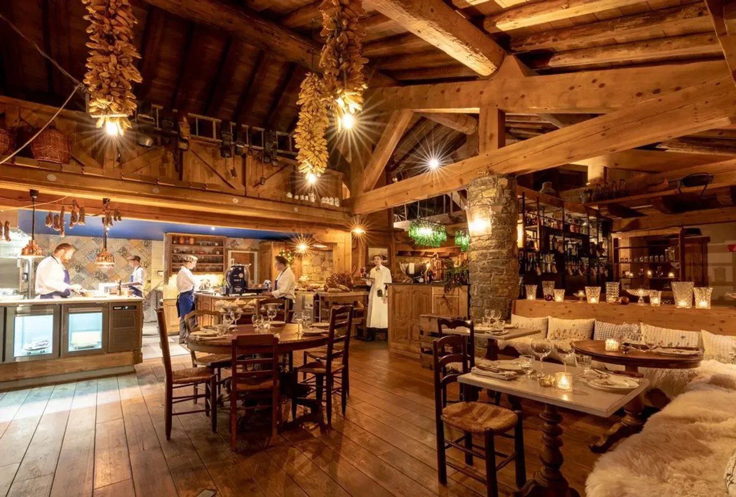 Cozy interior of La Table de Jeanne restaurant in Tignes, featuring wooden beams and decor.
