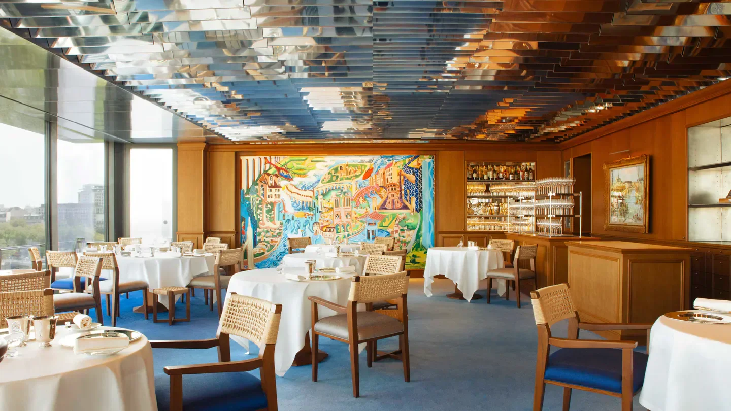 Interior dining room at La Tour d'Argent restaurant in Paris, featuring tables and art.