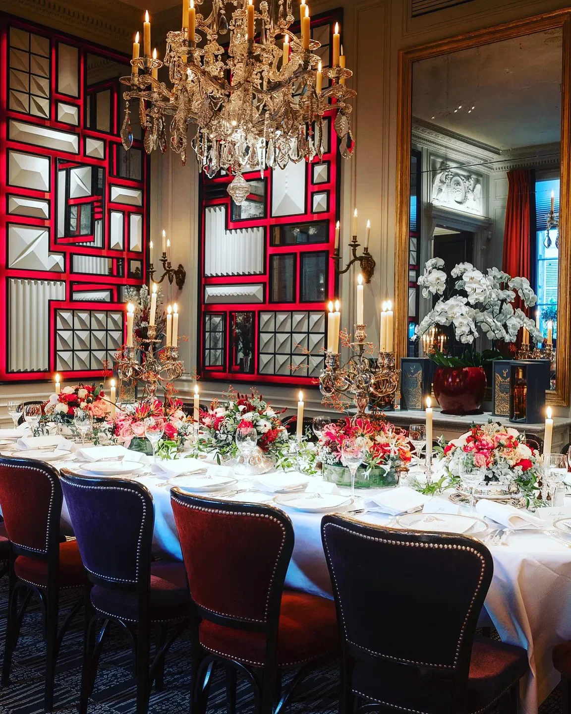Elegant dining room at L'Ambroisie in Paris, with floral table setting and chandeliers.