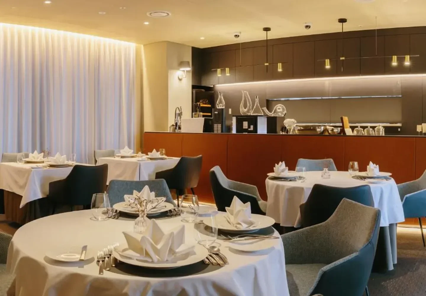 Elegant dining room at L'Amitié restaurant in Seoul, with table settings and chairs.