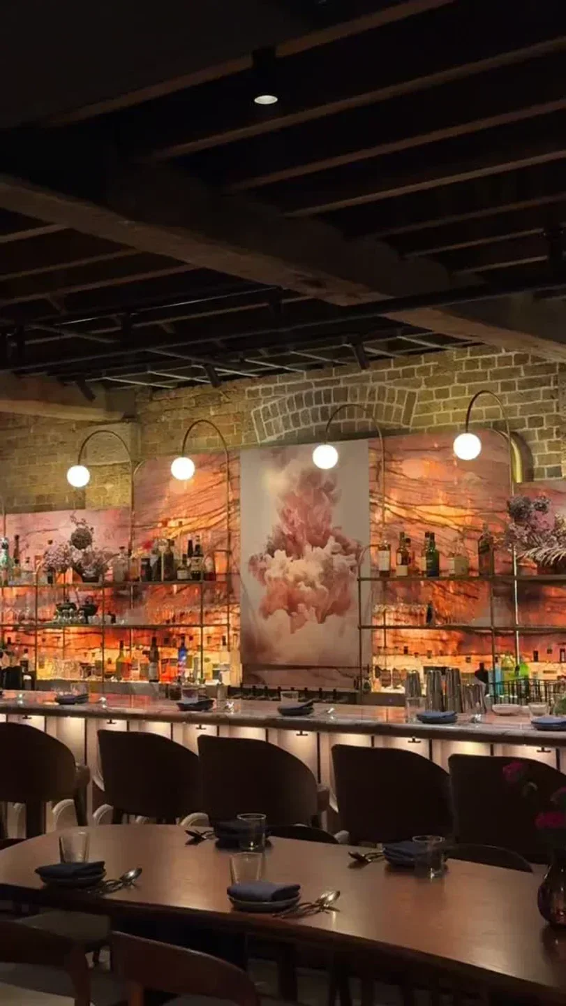 Interior of Lana restaurant in Sydney, featuring bar and dining area with artistic decor.