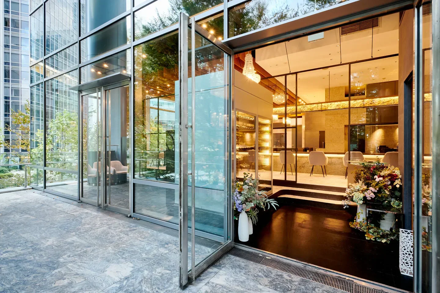 Entrance of L'ARGENT restaurant in Tokyo, showcasing elegant glass doors and interior design.