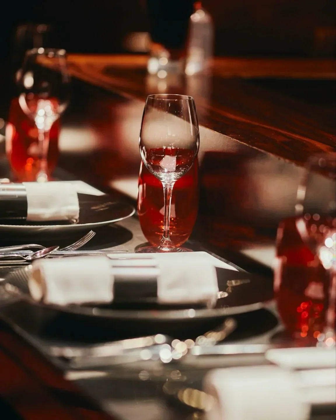 Elegant table setting at L'Atelier de Joël Robuchon - Étoile in Paris, with wine glasses.