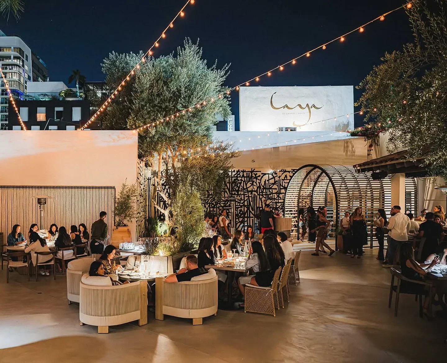 Outdoor dining at Laya Restaurant in Los Angeles, featuring stylish seating and string lights.