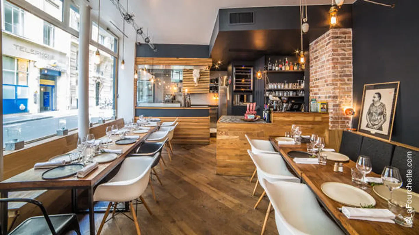 Interior of Le Boeuf Volant restaurant in Paris, featuring stylish decor and dining tables.