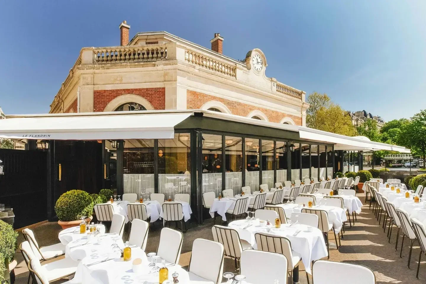 Outdoor seating at Le Flandrin restaurant in Paris, with elegant white table settings.