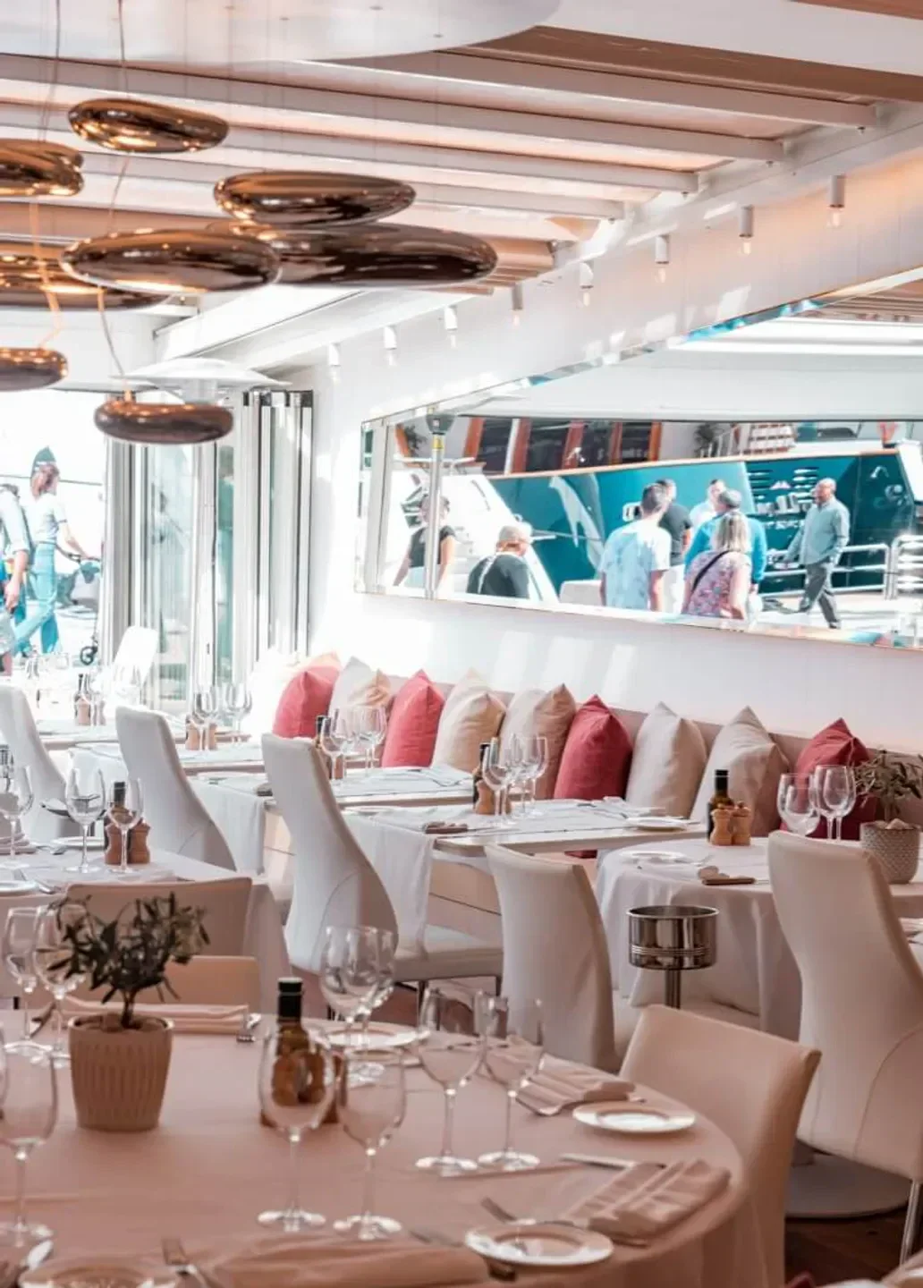 Elegant interior of Le Girelier restaurant in Saint-Tropez, with tables and mirror.