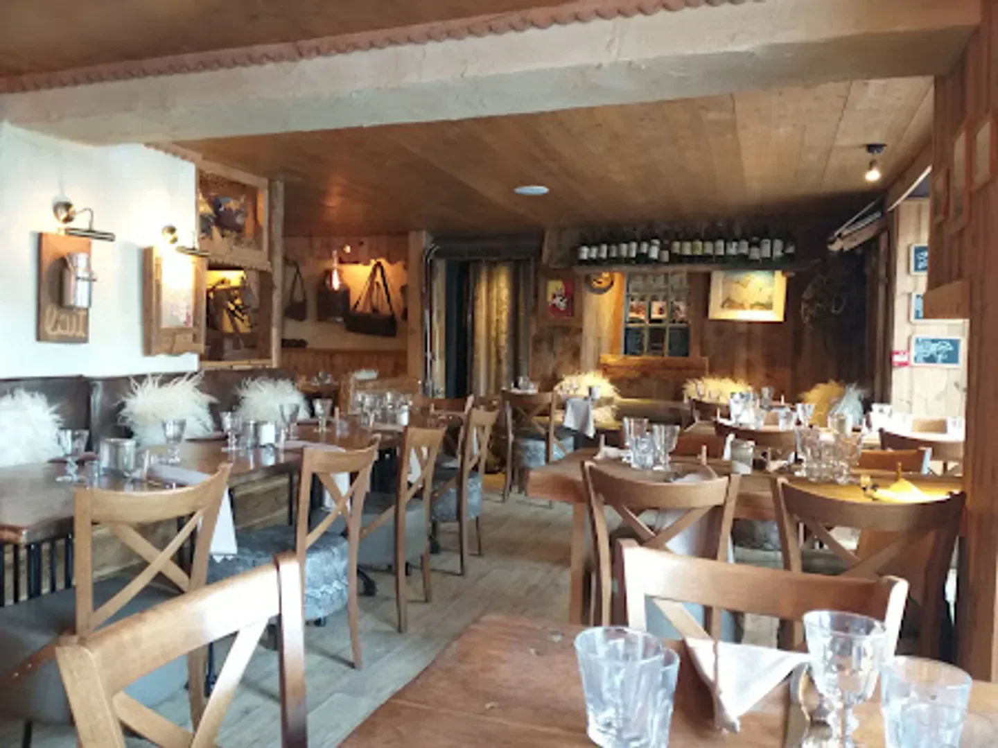 Cozy interior of Le Torrent restaurant in Megeve, featuring wooden tables and chairs.