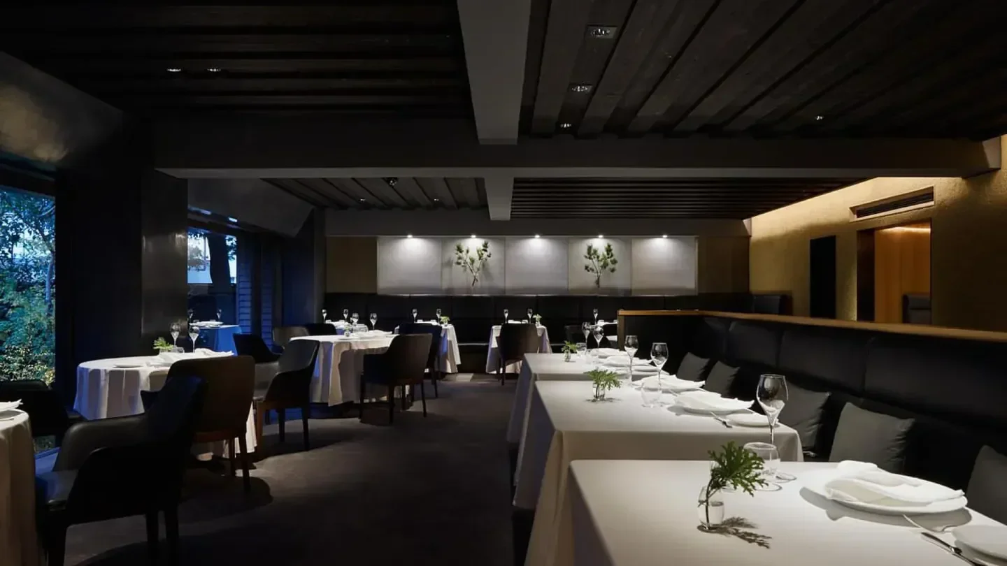 Elegant dining room interior at L'Effervescence in Tokyo, featuring pristine tables and decor.