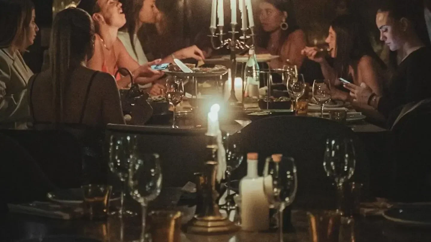 Candlelit dinner at Legends Dinner in Paris, with friends enjoying food and drinks.
