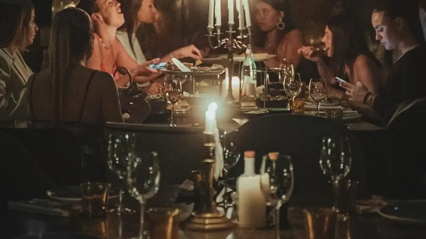 Candlelit dinner at Legends Dinner in Paris, with friends enjoying food and drinks.