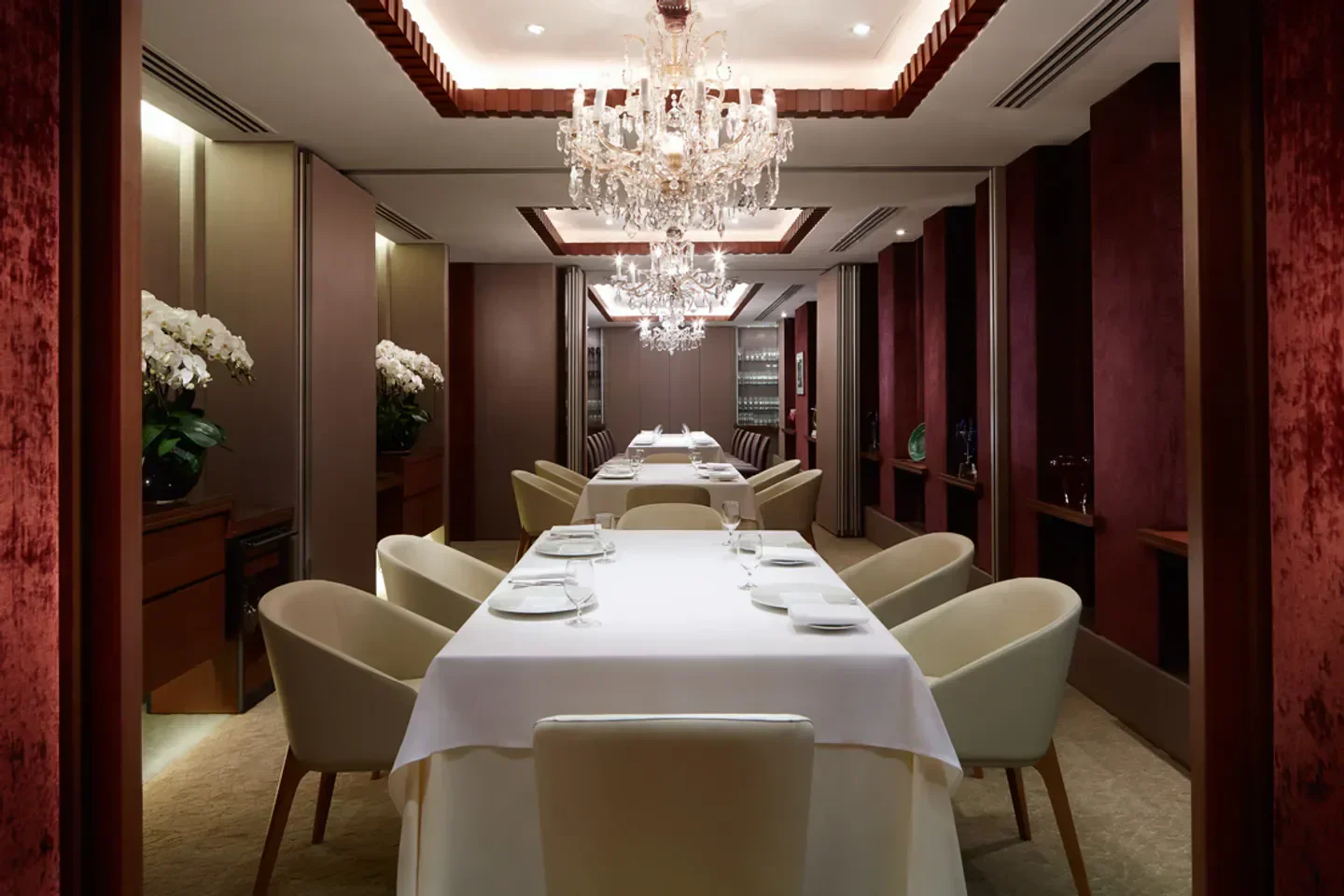 Elegant dining room at Les Amis restaurant in Singapore, featuring chandeliers and tables.