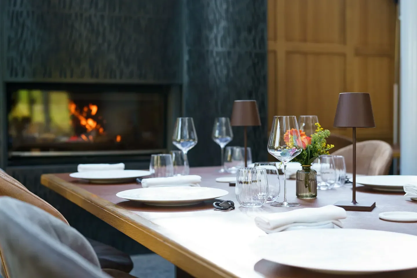 Cozy dining setting at Les Jardins d'Anaïs in Luxembourg, with fireplace and table decor
