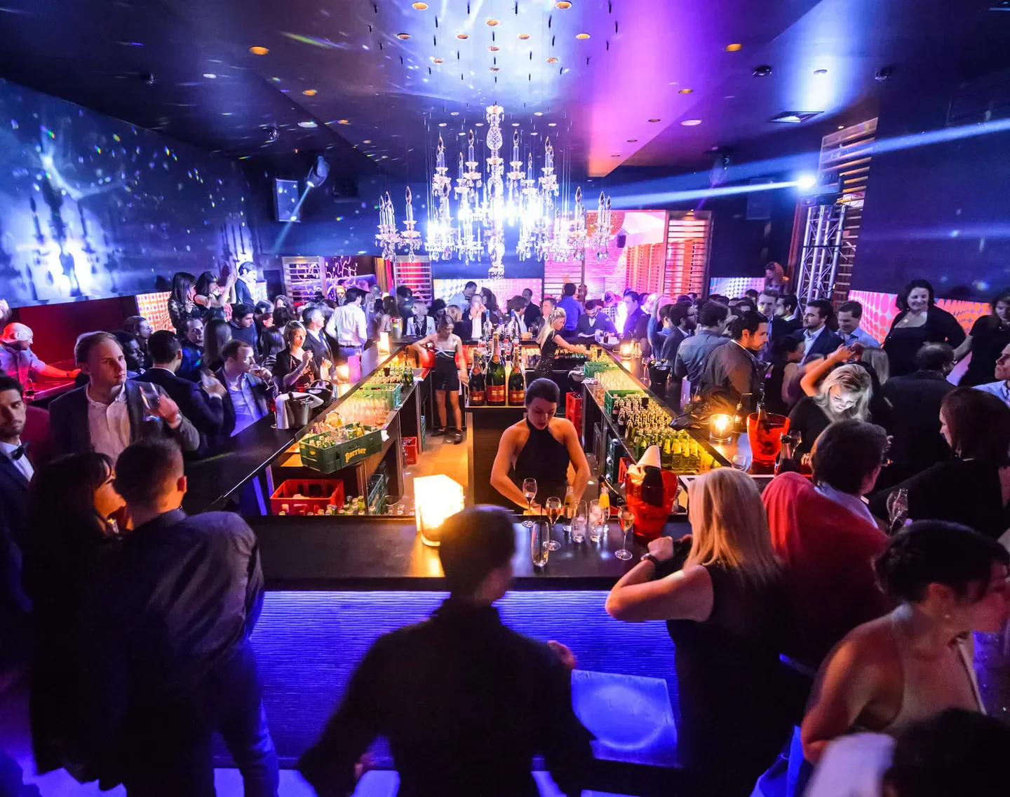 Inside Les Jeux d’Hiver nightclub in Brussels, busy bar scene with patrons and staff.