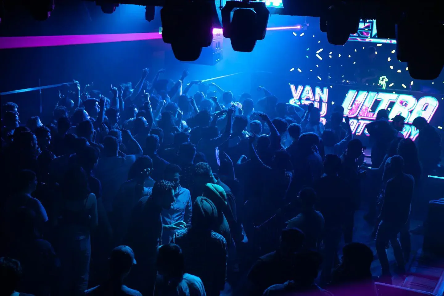 Energetic crowd at Levels Nightclub in Vancouver, illuminated by vibrant blue lights.