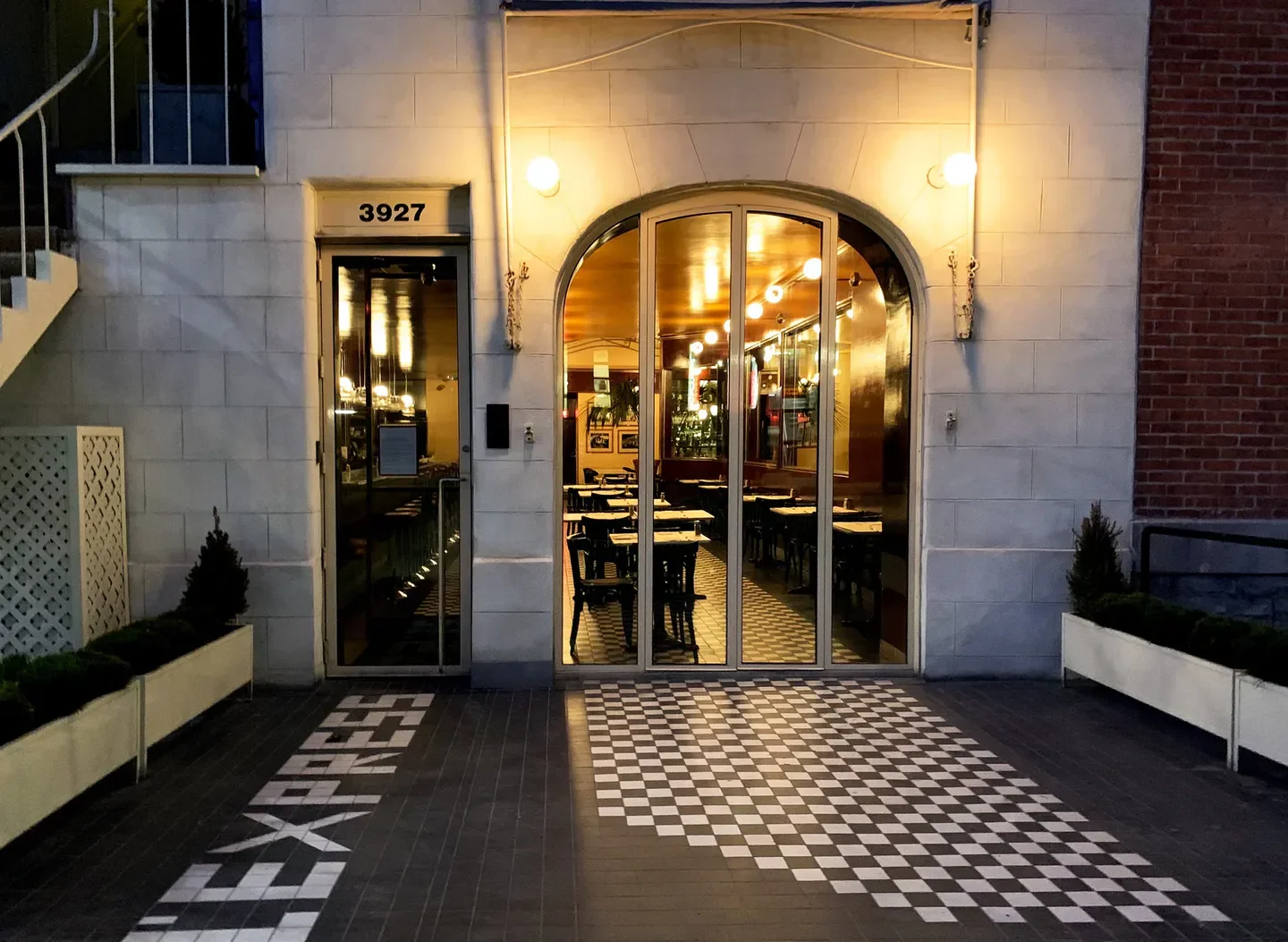 Exterior of L'Express restaurant in Montreal, with a tiled entrance and inviting lights.