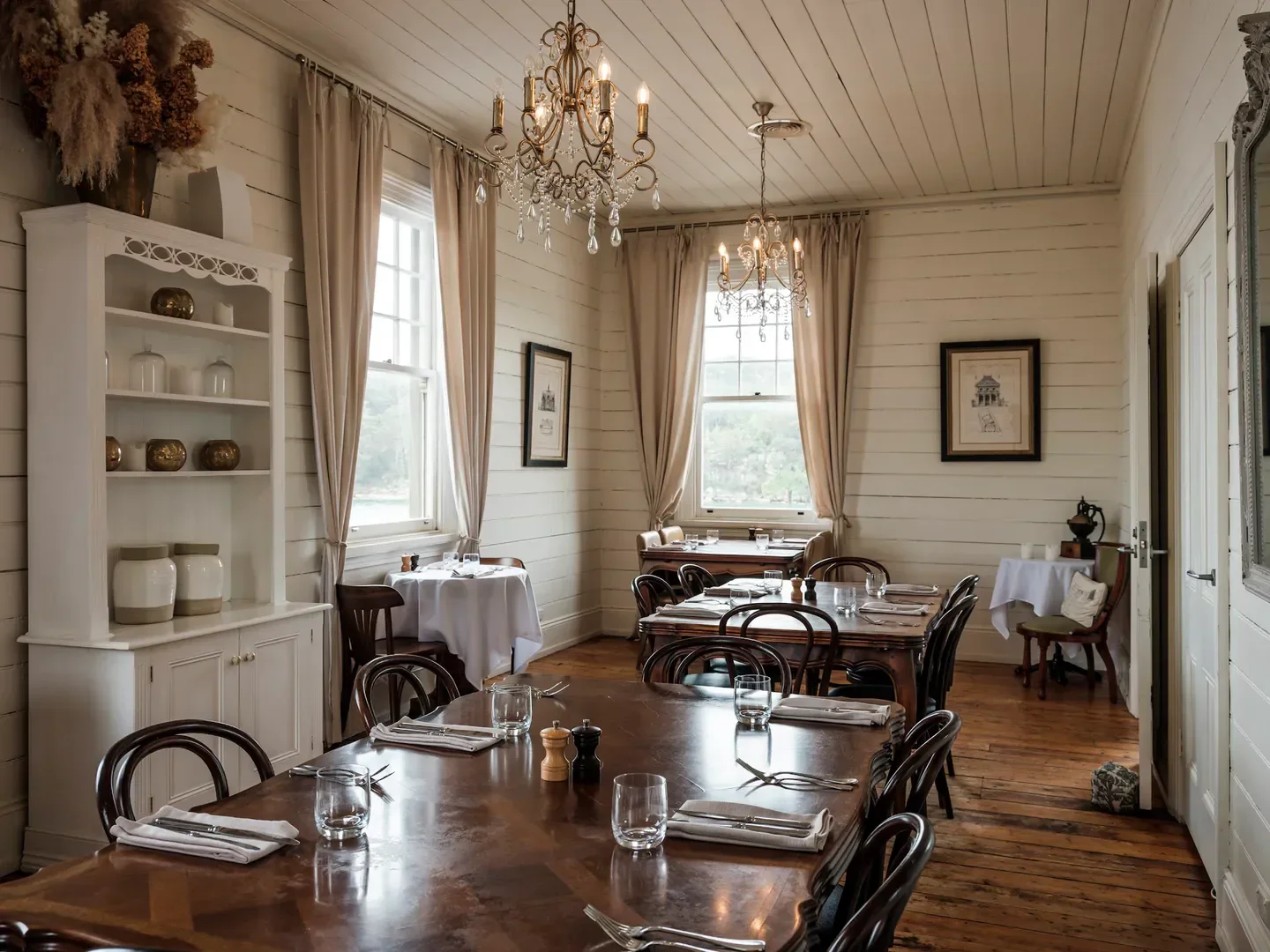 Elegant dining room interior at L'Heritage restaurant in Sydney, featuring chandeliers and a long table.