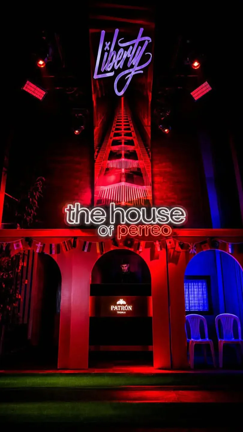 Liberty Club in the city, Spain, features neon "the house of perreo" sign and vibrant red and blue lighting.