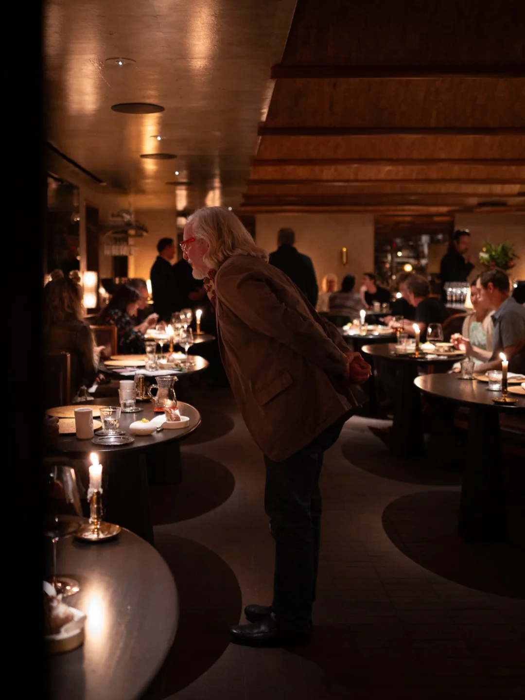 Warm, ambient dining room interior at Lielle restaurant, with elegantly set tables and soft lighting illuminating the city.