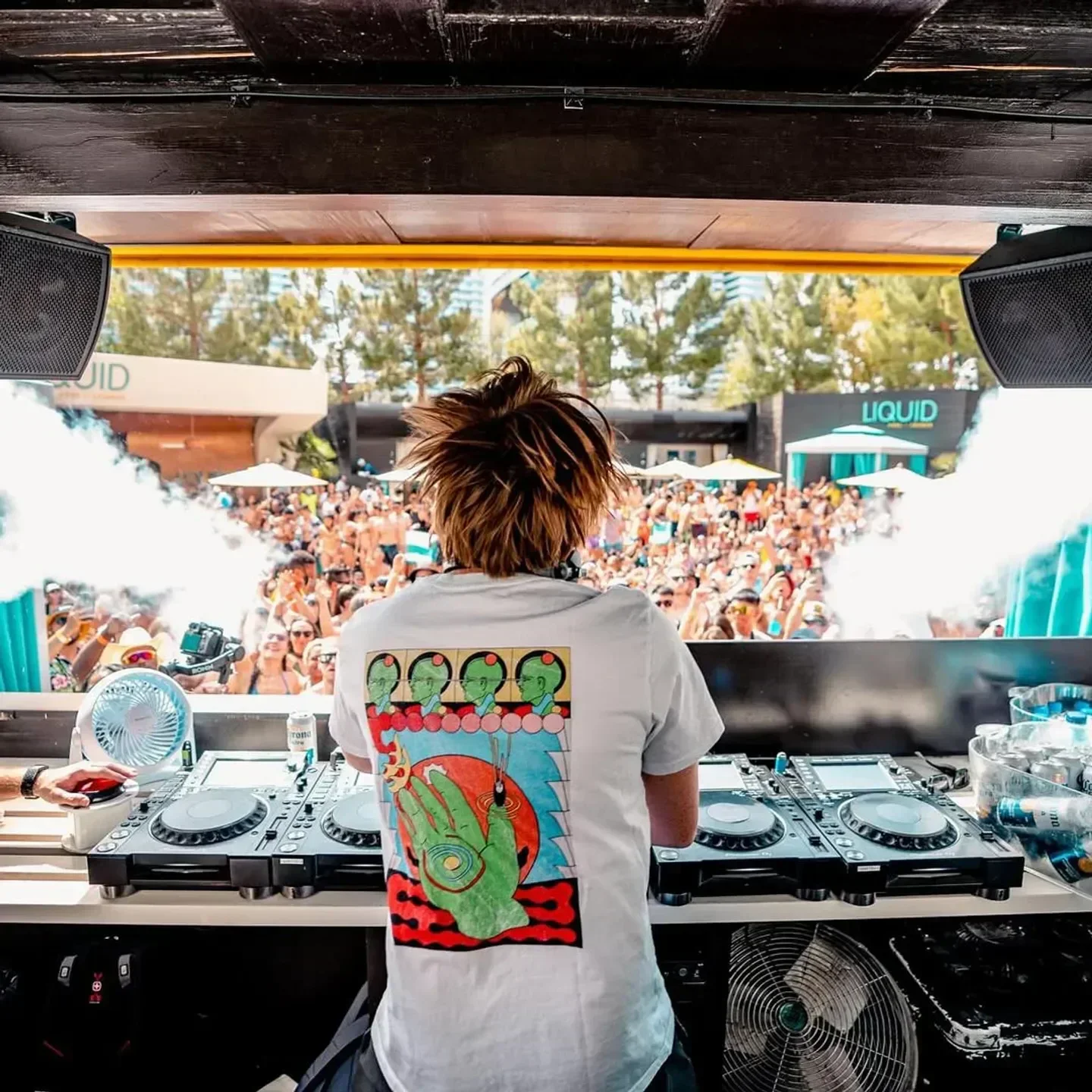 DJ at Liquid Pool in Las Vegas performing for a crowd at a daytime beach club party