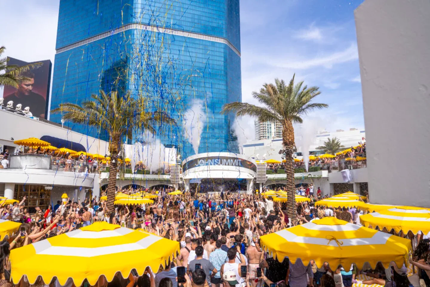 LIV Beach Las Vegas pool party with confetti and cheering crowds under bright yellow umbrellas.