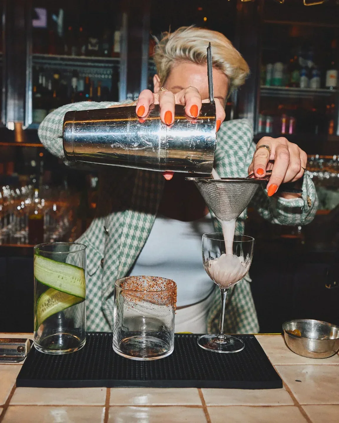 Bartender at Longshore in Sydney pouring cocktail, preparing drinks with style and flair.