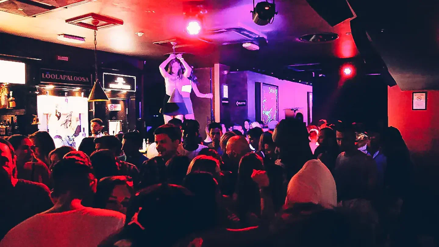 Energetic nightclub scene at LoolaPaloosa in Milan, with a crowd and stage performance.