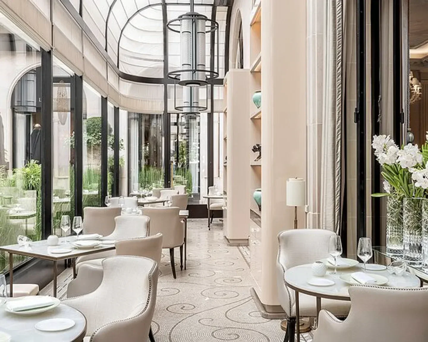 Elegant dining area at L'Orangerie restaurant in Paris, featuring natural light and stylish decor.