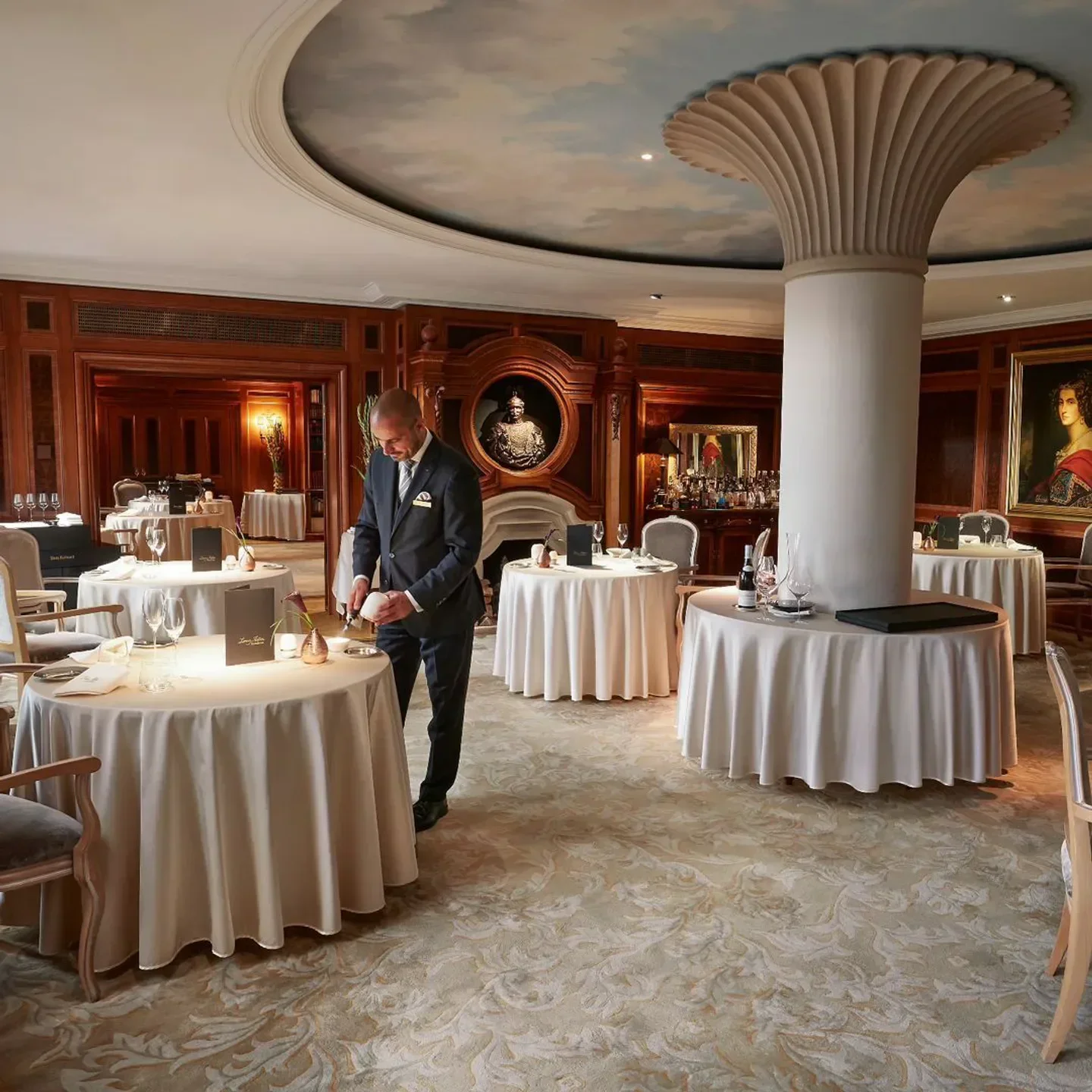 Elegant interior of Lorenz Adlon Esszimmer restaurant in Berlin with a waiter at work