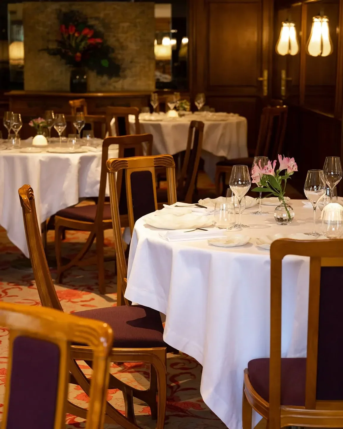 Elegant dining room interior at Lucas Carton - La Table in Paris, with tables set.