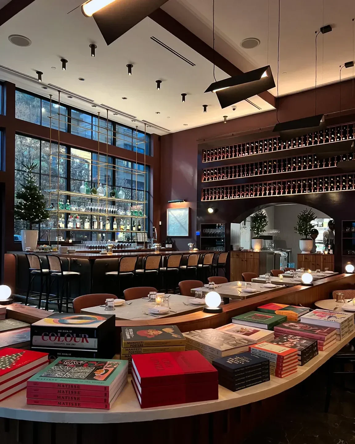 Interior of Lucian Books & Wine in Atlanta, with books, bar, and elegant dining tables.