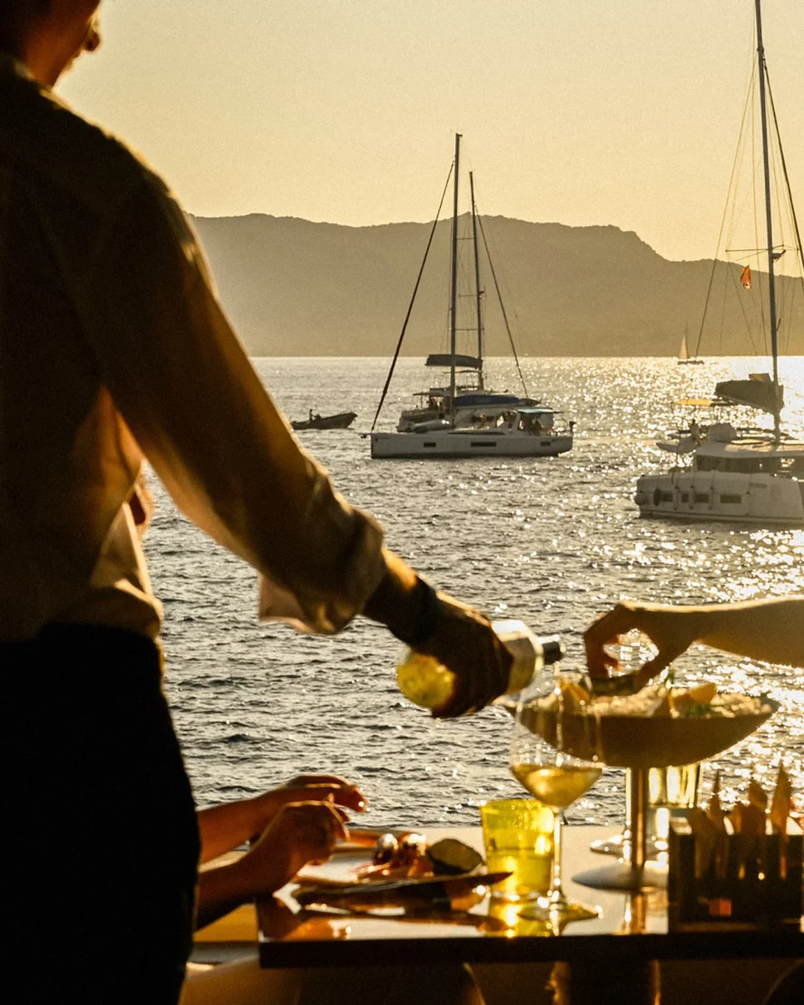 Dine at Luciano's in Porto Cervo with a stunning sunset view and yachts on the sea