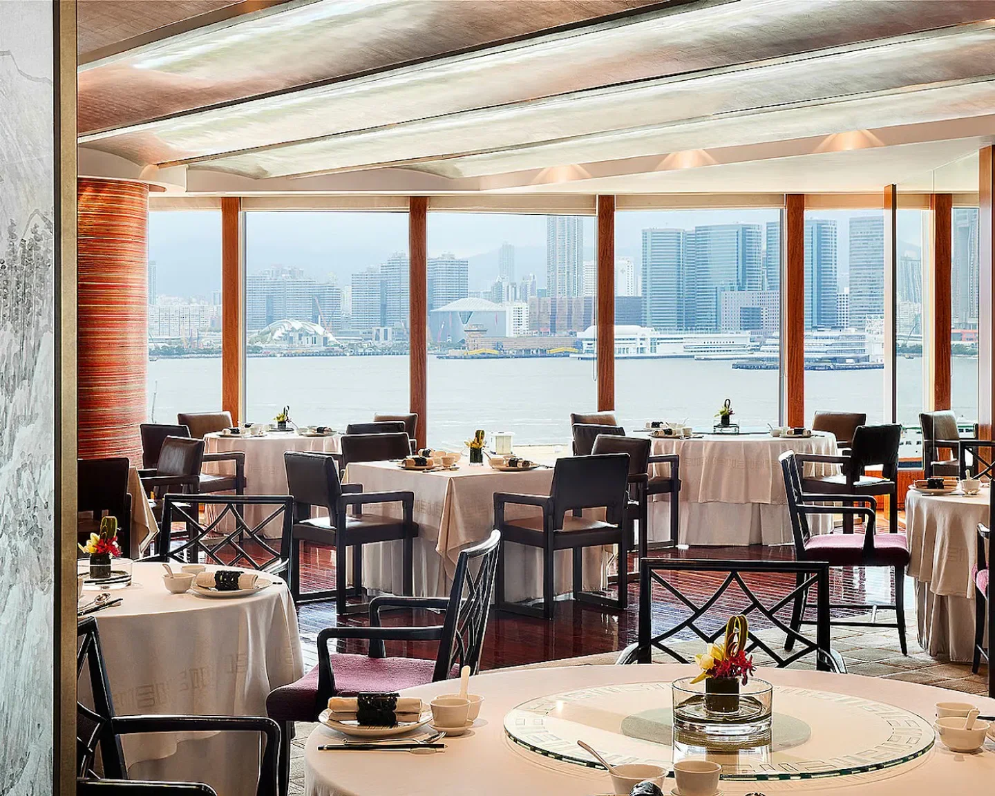 Elegant dining room at Lung King Heen restaurant in Hong Kong, with harbor views.